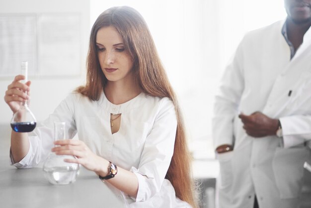 Experimente im chemischen Labor. Ein Experiment wurde in einem Labor in transparenten Kolben durchgeführt.