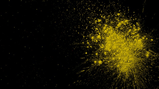 Explosion der trockenen gelben Farbe auf schwarzem Hintergrund