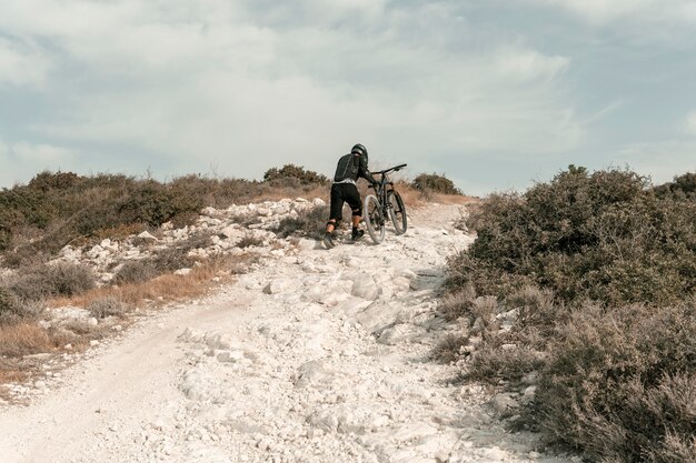 Extra langer Schuss Mann, der ein Mountainbike reitet