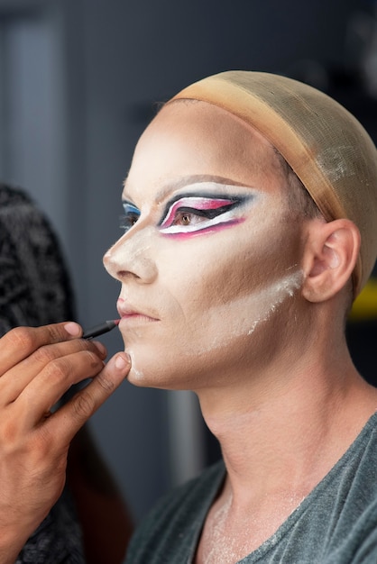 Kostenloses Foto fabelhafte drag queen macht ihr make-up fertig