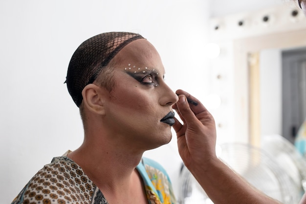 Kostenloses Foto fabelhafte drag queen macht ihr make-up fertig