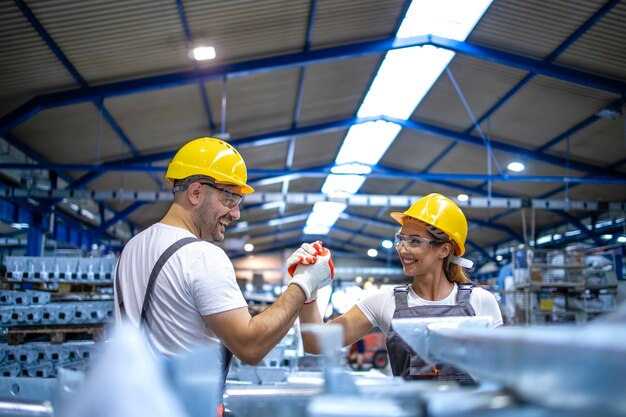 Fabrikarbeiter begrüßen sich an der Produktionslinie