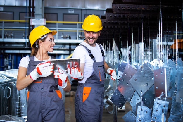Fabrikarbeiter, die in der industriellen Metallproduktionslinie zusammenarbeiten