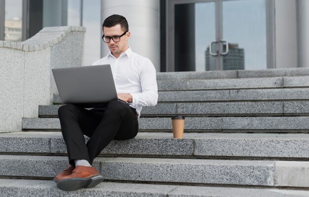 Fachmann, der draußen auf Laptop schaut