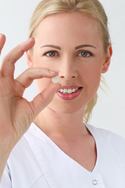 Fachmann. Schöne Kosmetikerin mit Tabletten