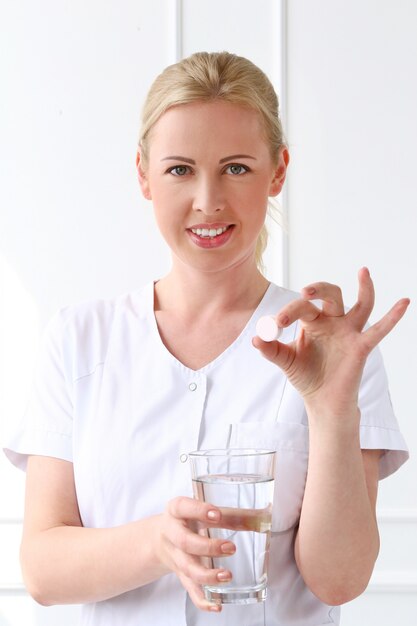 Fachmann. Schöne Kosmetikerin mit Tabletten