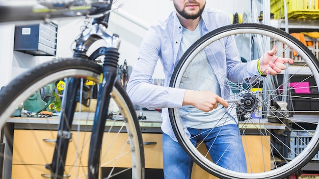 Fahrradmechaniker, der Fahrradreifen mit Schlüssel repariert