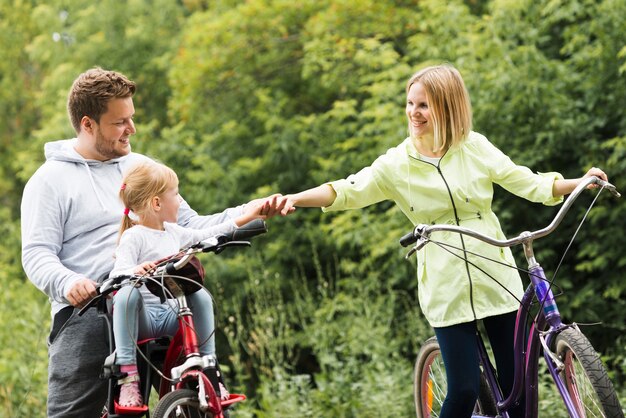 Familie auf dem Fahrrad, das Hände anhält