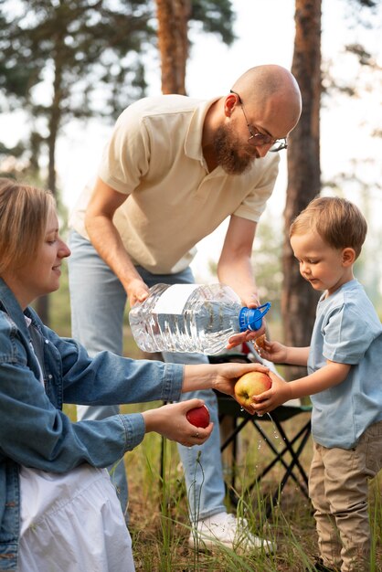 Familie bereitet Abendessen beim Camping vor