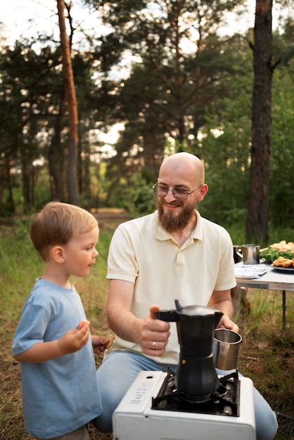 Familie bereitet Abendessen beim Camping vor