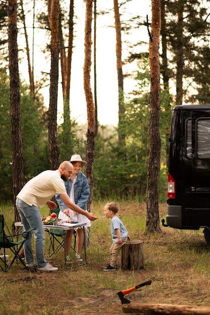 Familie bereitet abendessen beim camping zu