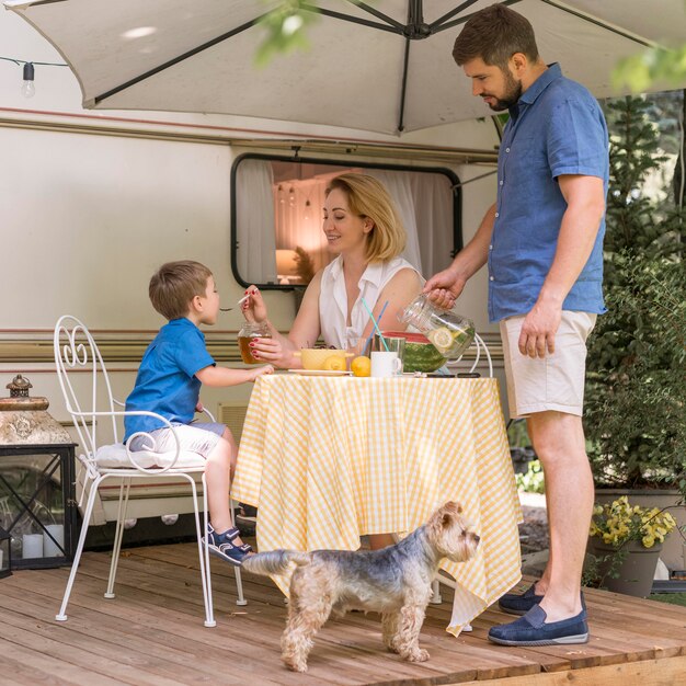 Familie, die das Mittagessen außerhalb eines Wohnwagens nimmt