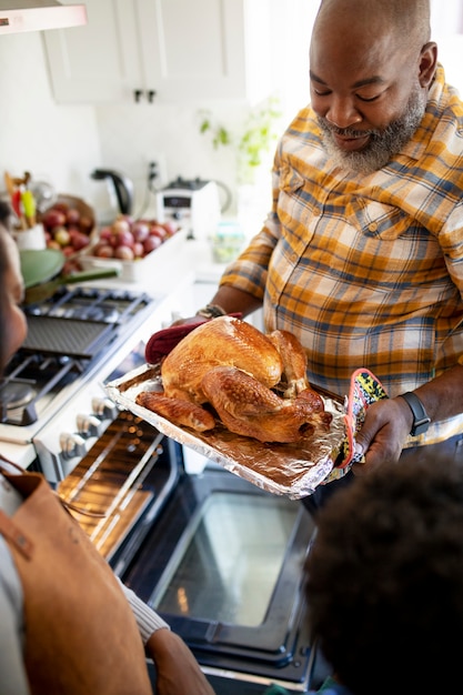 Kostenloses Foto familie, die den thanksgiving day truthahn vorbereitet