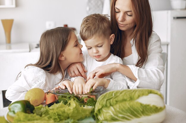 Familie, die einen Salat in einer Küche zubereitet