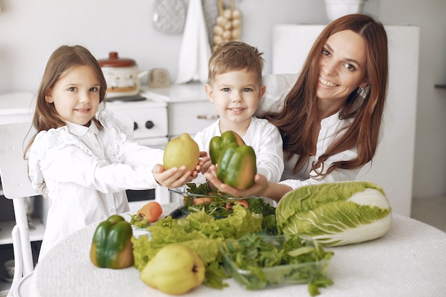 Familie, die einen Salat in einer Küche zubereitet