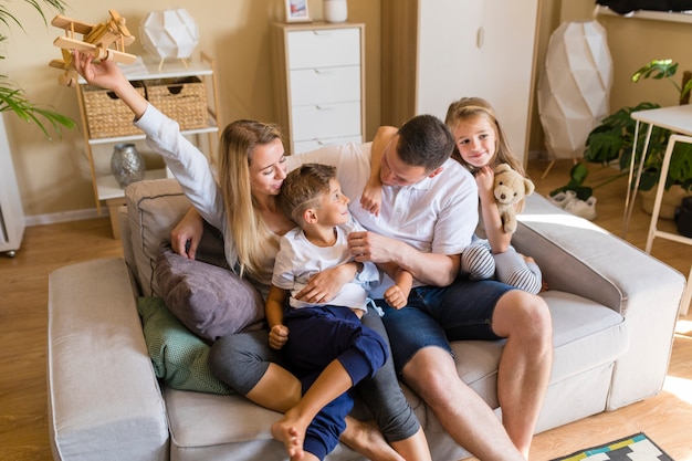 Familie, die im Wohnzimmer mit Spielwaren spielt