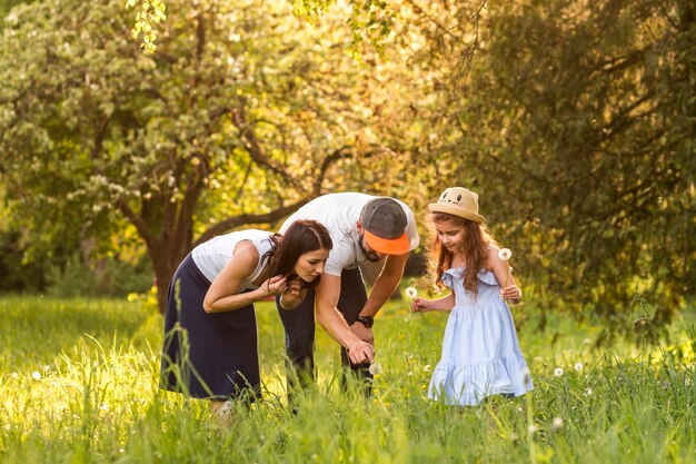 Familie, die Löwenzahnblume im Garten betrachtet