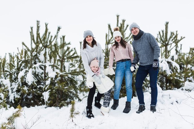 Familie, die nahe Fichten aufwirft