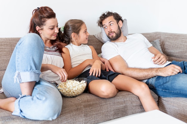 Familie, die Popcorn auf der Couch isst