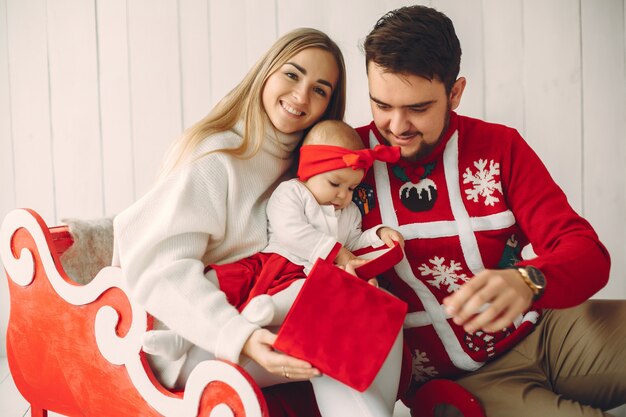 Familie, die zu Hause mit Weihnachtsgeschenken sitzt