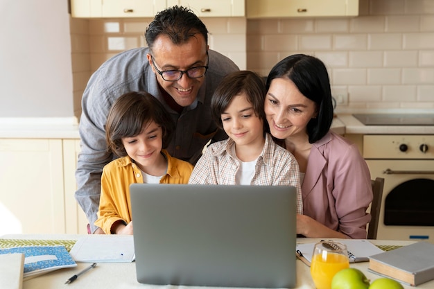 Familie, die zu Hause zusammen auf einem Laptop schaut