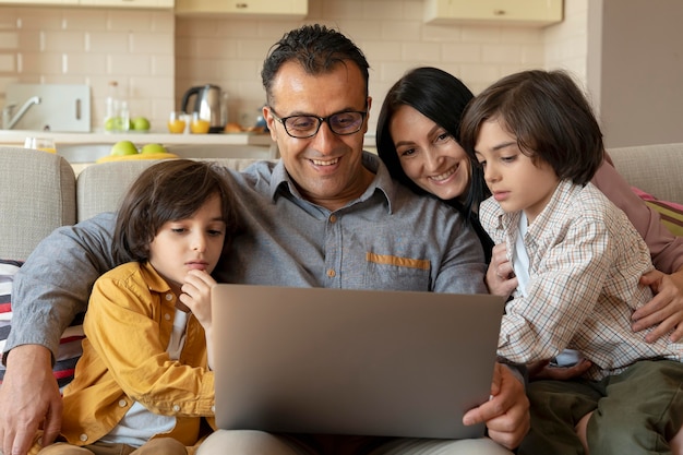 Familie, die zu Hause zusammen auf einem Laptop schaut