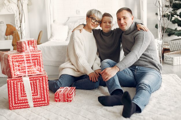 Familie in einem Raum. Kleiner Junge nahe der Weihnachtsdekoration. Mutter mit Vater mit Sohn