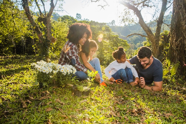 Familie liegt auf grasbewachsenen Hügel