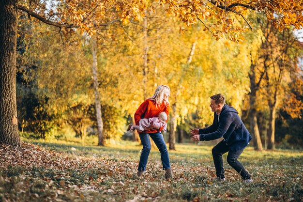 Familie mit der Babytochter, die in einen Herbstpark geht