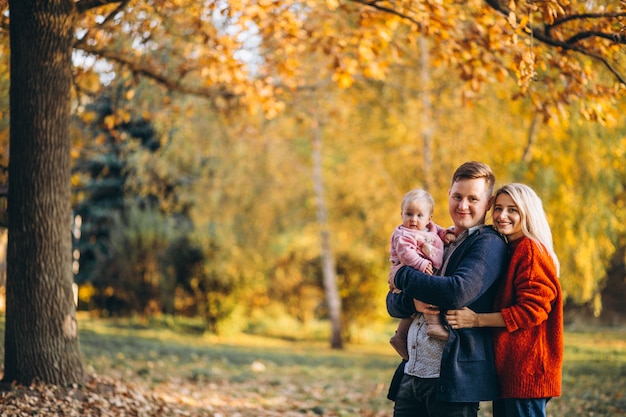 Familie mit der Babytochter, die in einen Herbstpark geht