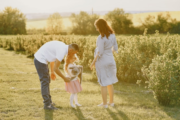 Familie mit der kleinen Tochter, die Zeit zusammen im sonnigen Feld verbringt