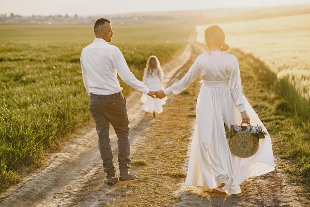 Familie mit der kleinen Tochter, die Zeit zusammen im sonnigen Feld verbringt