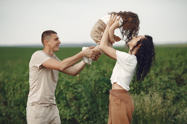 Familie mit der kleinen Tochter, die Zeit zusammen im sonnigen Feld verbringt