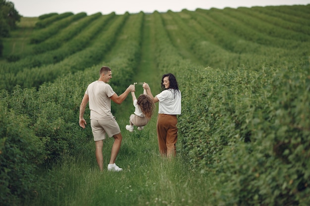 Familie mit der kleinen Tochter, die Zeit zusammen im sonnigen Feld verbringt