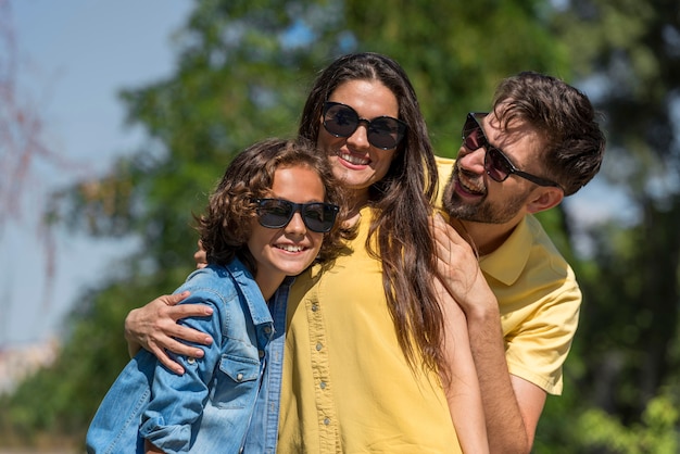 Familie mit Eltern und Kind, die zusammen im Park aufwerfen