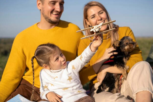 Familie mit Kind und Hund, die mit Flugzeugspielzeug spielen