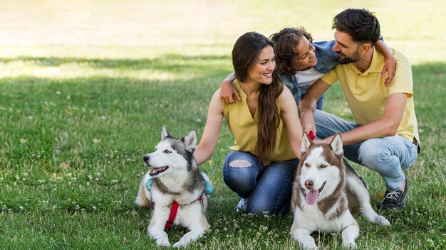 Familie mit Kind und Hunden im Freien zusammen