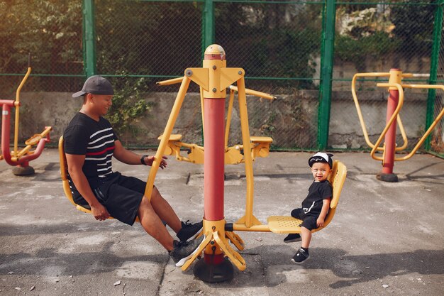 Familie mit kleinem Sohn, der auf einem Spielplatz spielt