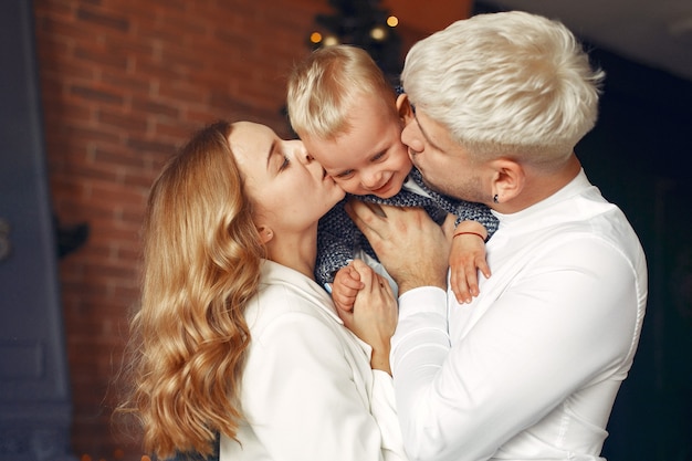 Familie mit kleinem sohn zu hause nahe weihnachtsbaum