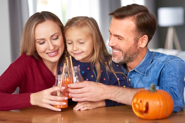 Familie mit Kürbis-Smoothie, der einen Toast auf Halloween macht