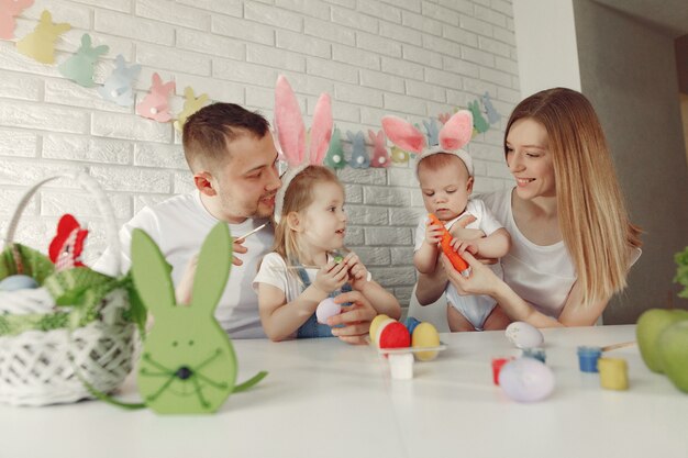 Familie mit zwei Kindern in einer Küche, die Ostern vorbereitet