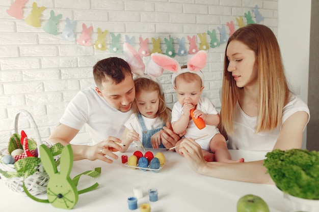 Familie mit zwei Kindern in einer Küche, die Ostern vorbereitet