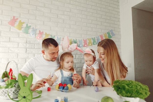 Familie mit zwei Kindern in einer Küche, die Ostern vorbereitet