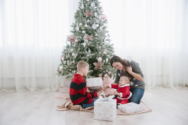 Familie neben Weihnachtsbaum