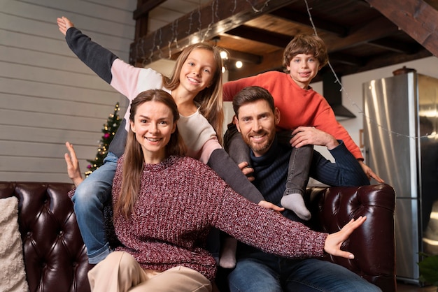 Kostenloses Foto familie posiert zusammen neben einem weihnachtsbaum