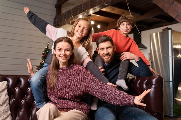 Familie posiert zusammen neben einem Weihnachtsbaum