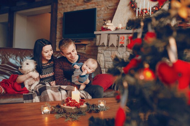 Familie sitzt auf der Couch mit Weihnachtsbaum unscharf vor