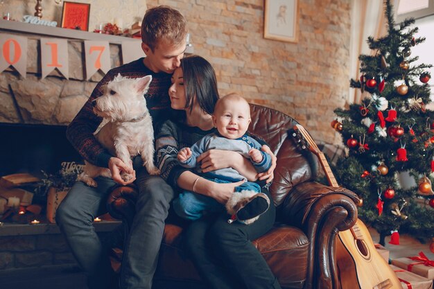 Familie sitzt auf einem Sofa mit Hund zu Weihnachten