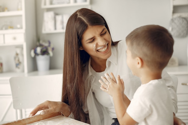 Familie sitzt in einer Küche und kocht den Teig für Kekse