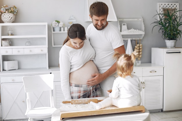 Familie sitzt in einer Küche und kocht den Teig für Kekse